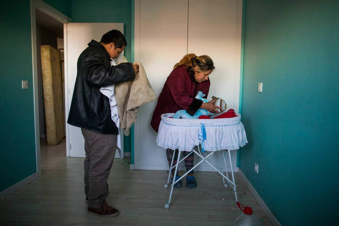 Furniture are packed behind the main door to stop riot police to enter the apartment as Cecilia Paredes and her husband Wilson Ruilova prepares to leave with their baby Dilan during their eviction in Madrid, Spain, Friday, Jan. 23, 2015. Paredes, 43, and her unemployed electrician husband Wilson Ruilova, 35, both from Ecuador, have three children: Dilan, a baby born less than two months ago; Andres, 16, and Miguel, seven. They have been unable to pay their rent after she lost her job as an elderly care assistant two years ago. The government company that owned the apartment sold it last year to an investor group along with more than 1,800 other apartments built for the needy and the new owner sought the family’s eviction. (AP Photo/Andres Kudacki)