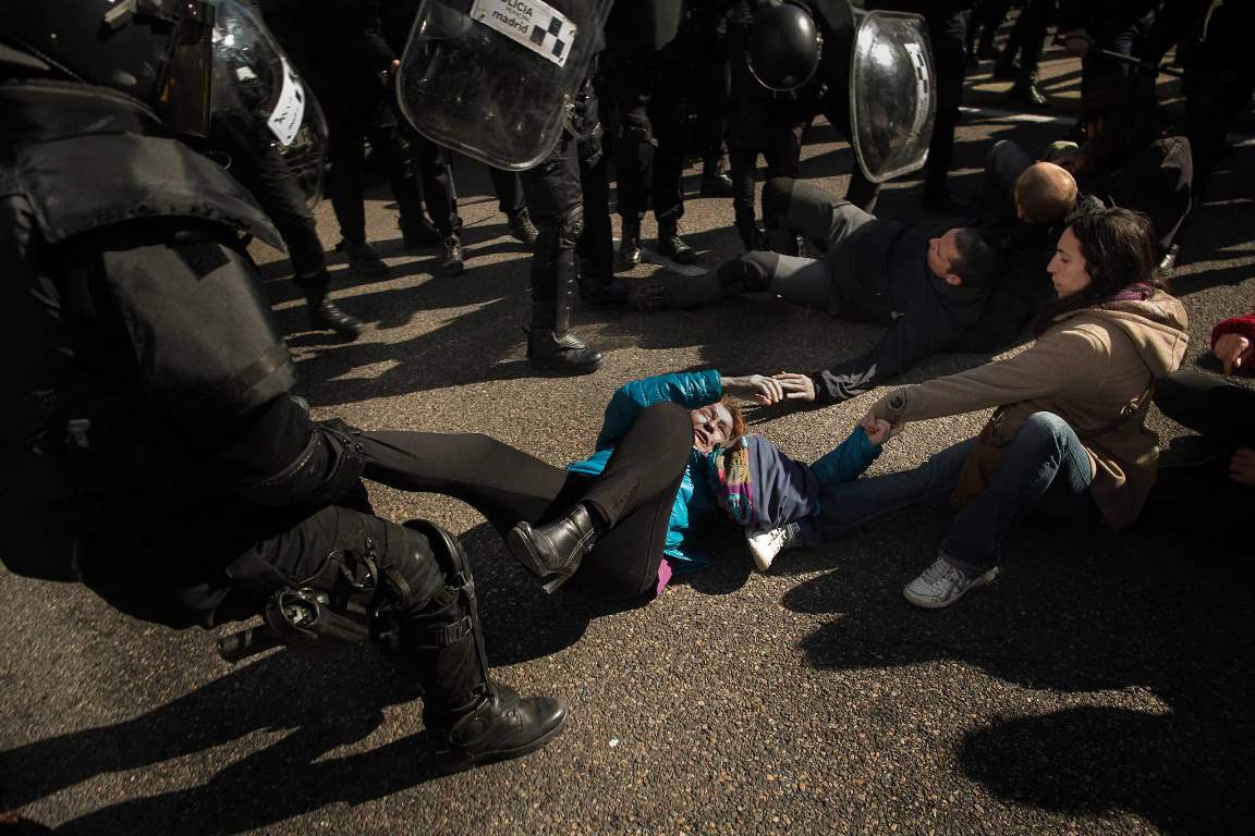 Riot Police remove housing rights activists as they tries to stop Luisa Gracia Gonzalez and her family's eviction and the demolition of their house by a forced expropriation in Madrid, Spain, Friday, Feb. 27, 2015. Madrid authorities say 11 people were arrested after several dozen protesters clashed with police who were carrying out an eviction order. A city spokeswoman said seven people were arrested for throwing gasoline at police officers, though she said the fuel was not set alight. The official spoke on condition of anonymity in keeping with city hall rules. Evictions in Spain have soared since the country's economic crisis began in 2008 and increasing numbers of people were unable to meet mortgage payments. Protesters regularly try to prevent evictions, but Friday's clash was particularly tense after a campaign to keep the family in its home. The house was expropriated for demolition as part of new urban project. Some 30 protesters tried to stop it, accusing authorities of real estate speculation. (AP Photo/Andres Kudacki)