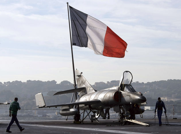 French sailors walk by a Super-Etendard jetfighter on the deck of France's nuclear-powered aircraft carrier Charles de Gaulle before to leave its home port of Toulon, southern France, Wednesday, Nov.18, 2015. France has decided to deploy its aircraft carrier in the eastern Mediterranean sea for fighting Islamic State group.(AP Photo/Claude Paris)